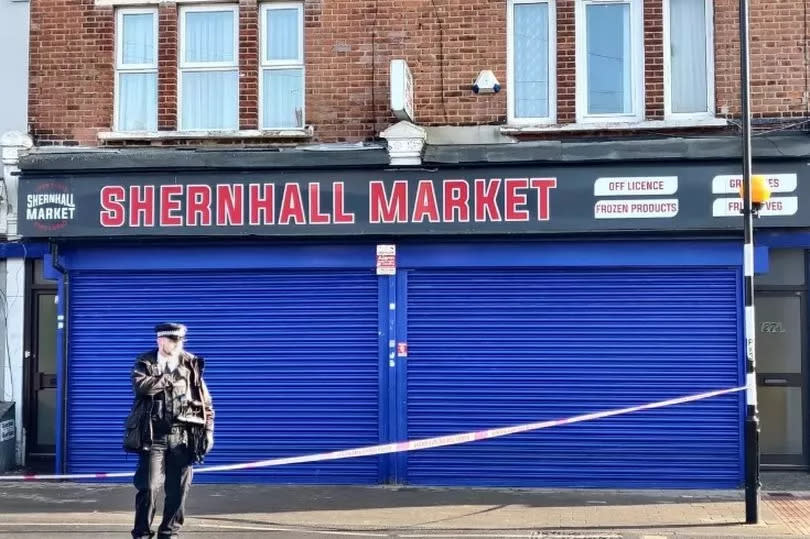 A police officer standing outside Shernall Market where Jaydon Brown fled with a near fatal neck wound