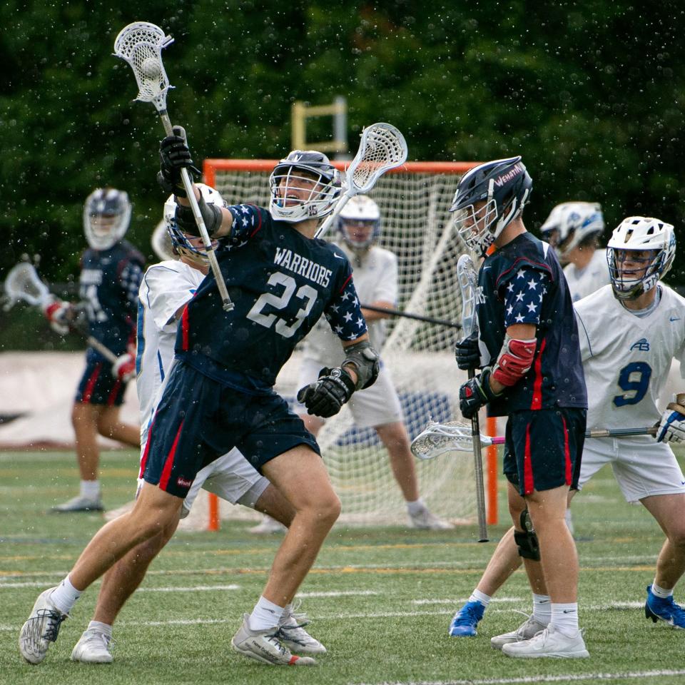 Lincoln-Sudbury senior captain Ryan Winters pulls down a loose ball, as rain falls during the Elite 8 playoff game against Acton-Boxborough at Leary Field in Acton, June 9, 2023. The Revolution defeated the Warriors, 15-7.