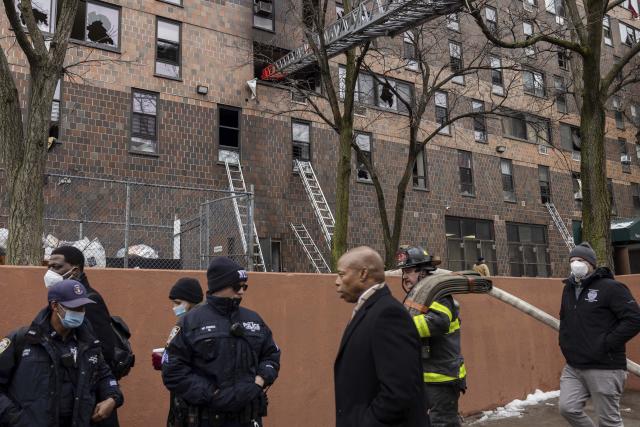 FILE — New York Mayor Eric Adams, center, visits an apartment building in The Bronx borough of New York, Jan. 9, 2022, where a fire killed 17 people. "Outside of 9/11, I don't know if another mayor was just inundated with so much at one time," he remarked. (AP Photo/Yuki Iwamura)