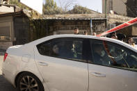 Israeli police arrest a young Palestinian woman, far rear window of the car, following a stabbing attack in the Sheikh Jarrah neighborhood in east Jerusalem, Wednesday, Dec. 8, 2021. An Israeli woman was stabbed and lightly wounded in east Jerusalem on Wednesday. The suspect, a Palestinian female minor, fled the scene and was later arrested inside a nearby school, police said. (AP Photo/Maya Alleruzzo)