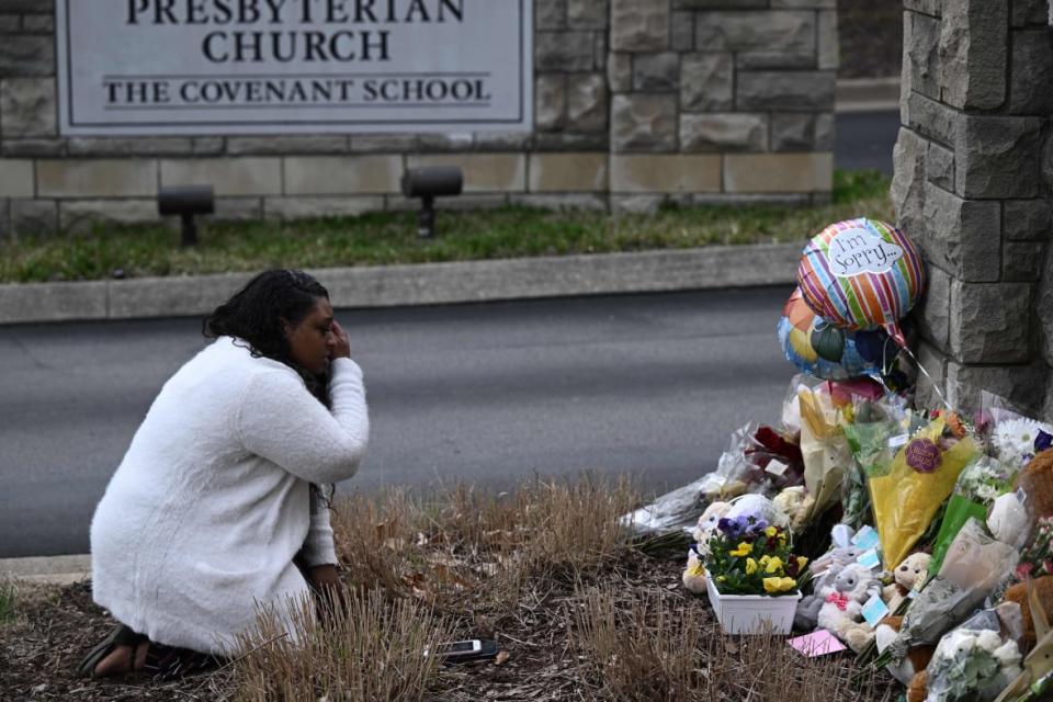A woman pays her respects at a makeshift memorial for victims outside the Covenant School building at the Covenant Presbyterian Church following a shooting, in Nashville, Tennessee, on March 28, 2023. (Photo by Brendan SMIALOWSKI / AFP) (Photo by BRENDAN SMIALOWSKI/AFP via Getty Images)