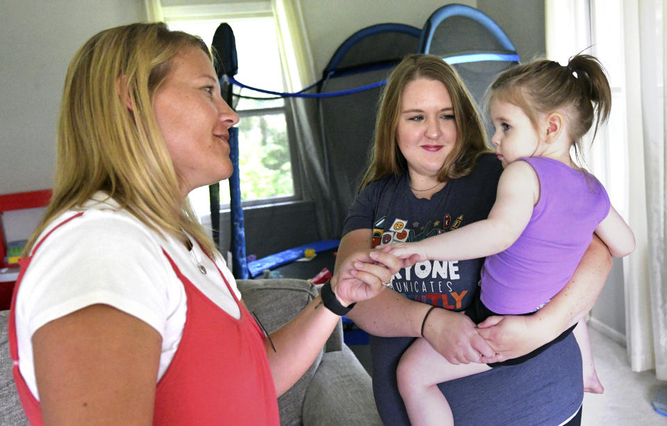 Early Intervention speech pathologist Megan Sanders, left, greets 2-year-old Aria Faulkner at parents Lindsey and Kendrick Faulkner's home in Peoria, Ill., Aug. 15, 2023. (AP Photo/Ron Johnson)