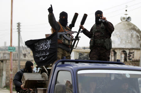 FILE PHOTO: Members of al Qaeda's Nusra Front gesture as they drive in a convoy touring villages, which they said they have seized control of from Syrian rebel factions, in the southern countryside of Idlib, Syria December 2, 2014. REUTERS/Khalil Ashawi/File Photo