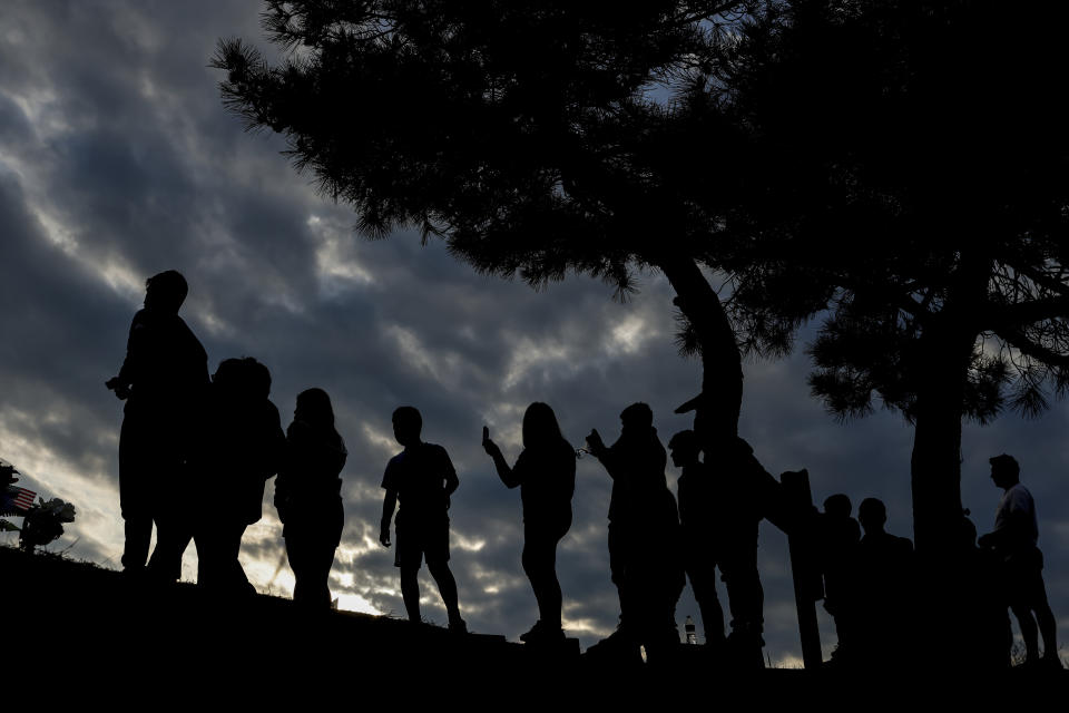 People watch as workers start to remove a section of the collapsed Francis Scott Key Bridge, late Sunday, March 31, 2024, in Baltimore. (AP Photo/Julia Nikhinson)