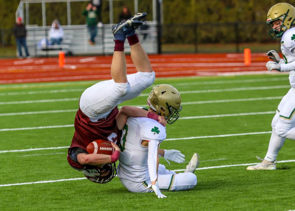 Nick Hyland of Bishop Stang is sent tumbling on this tackle by Connor McHale of Bishop Feehan during the fourth quarter of Feehan's 42-8 Thanksgiving Day win.