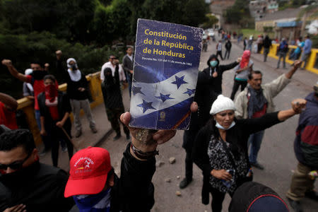 An opposition supporter holds up the Constitution of the Republic of Honduras during a protest over a contested presidential election with allegations of electoral fraud in Tegucigalpa, Honduras, December 22, 2017. REUTERS/Jorge Cabrera