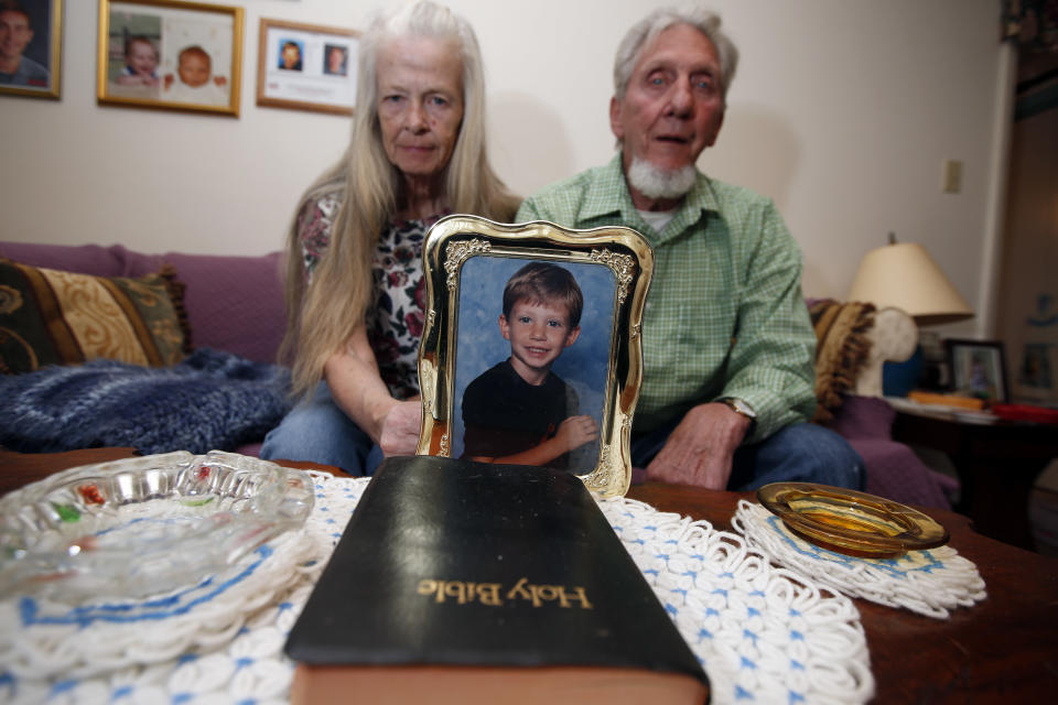 This photo taken April 29, 2014 shows Nettie Shoemaker and her husband Victor Shoemaker Sr., posing for a photograph holding a picture of their son in their home, in Leesburg, Va. Twenty years after Victor Dwight Shoemaker Jr., vanished while playing with two cousins along a West Virginia mountainside, his parents hold the belief that their only child is still alive. The boy known as J.R. had been in the woods behind his grandfather's mobile home in Hampshire County when two cousins emerged without him on May 1, 1994. No trace of him was ever found. (AP Photo/Alex Brandon)