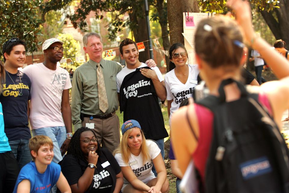 Journalism major Erin Jester takes a group photo of Gainesville Mayor Craig Lowe with University of Florida students gathered in support of National Coming Out Day, hosted by the Lesbian Gay Bisexual Transgender Affairs (LGBT) on campus Monday, October 11, 2010 in Gainesville, Fla. National Coming Out Day, founded in 1988, celebrates the Second National March on Washington for Lesbian and Gay Rights, in which 500,000 people participated in the effort to fight for equality.