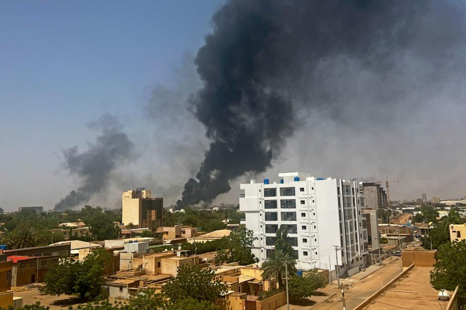 Smoke billows above residential buildings in Khartoum on April 16, 2023, as battles raged between the forces of rival generals.