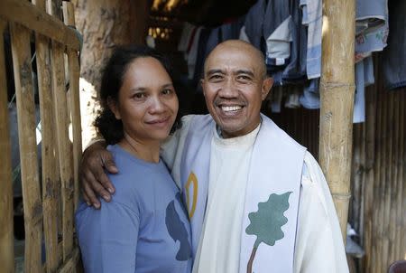 Roman Catholic priest Father Jess Siva poses with his common law wife Bemma at the entrance of their house in Iloilo city on Panay island in central Philippines January 10, 2015. REUTERS/Erik De Castro