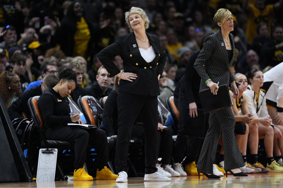 Iowa head coach Lisa Bluder, left, reacts to a call during the first half of the Final Four college basketball championship game against South Carolina in the women's NCAA Tournament, Sunday, April 7, 2024, in Cleveland. (AP Photo/Carolyn Kaster)