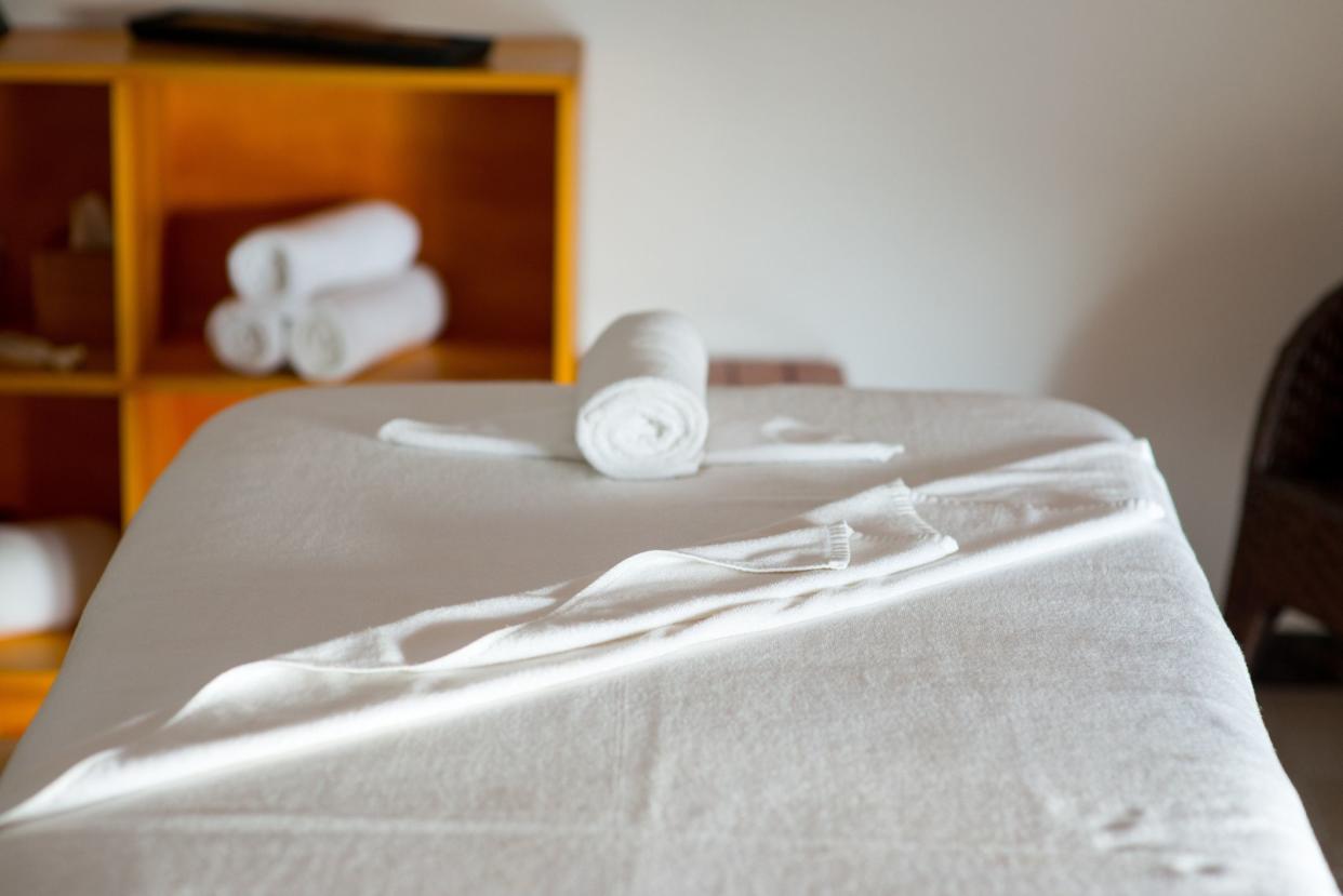 rolled towel on massage table in spa center