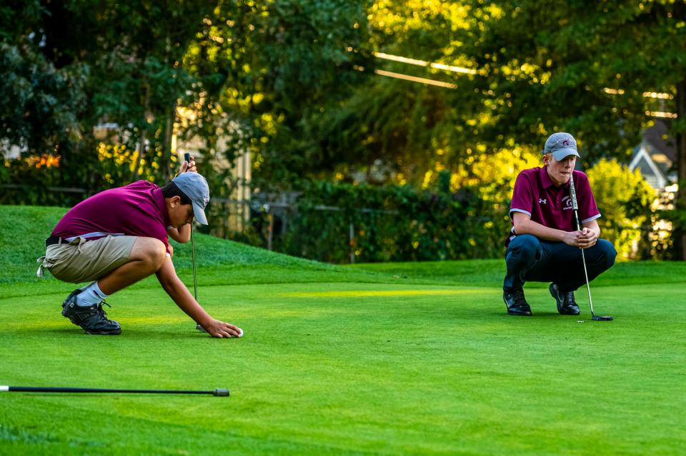 Bishop Stang's Matthew Oliveira sets his ball while his teammate, Matt Costello studies the green on Hole 8 at the Country Club of New Bedford.