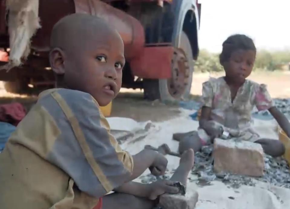 Niños muelen trozos de mineral de mica afuera de una mina de ese material en el sur de Madagascar. (Captura de pantalla / NBC News)