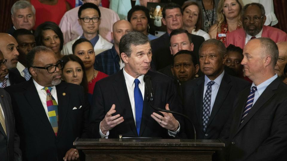 FILE - In this Friday, June 28, 2019 file photo, North Carolina Gov. Roy Cooper announces that he plans to veto a GOP-backed state budget during a press conference at the Executive Mansion in Raleigh, N.C. North Carolina Gov. Roy Cooper signed an order Friday, Aug. 2, 2019 barring the state health department from allowing public funds to pay for conversion therapy for minors, a controversial practice aimed at changing young LGBT people’s sexual orientations.(Travis Long/The News & Observer via AP, File)