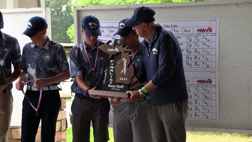 Hillsdale Academy coach Rolla Frisinger earned Regional Coach of the Year honors from the MIGCA.  He is pictured handing the team their runner-up trophy at the D4 state finals.