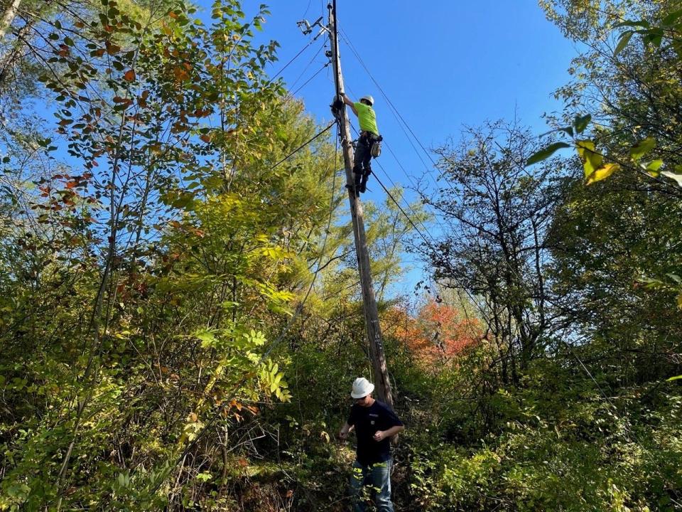 Tyler Eastman, a lineman for Consolidated Communications, climbs a utility pole on Oct. 4, 2023, on Goose Pond Road in Fairfax to install high-speed fiber optic cable.
