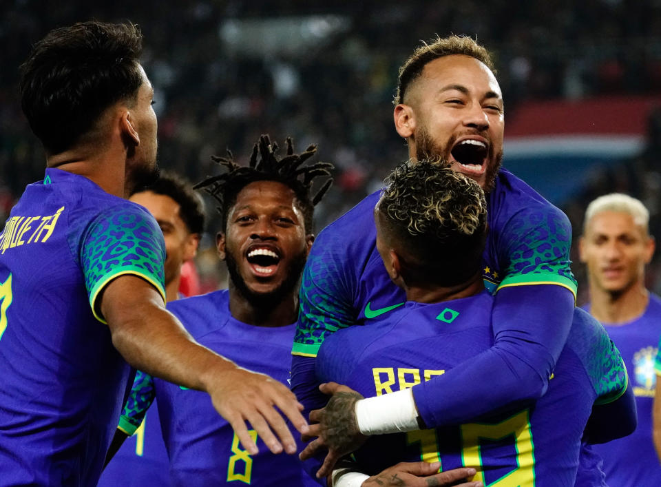 PARIS, FRANCE - SEPTEMBER 27: Neymar of Brazil celebrates with Raphinha of Brazil  after he scores a penalty to make it 4-1 during the International Friendly between Brazil and Tunisia at Parc des Princes on September 27, 2022 in Paris, France. (Photo by Marc Atkins/Getty Images)