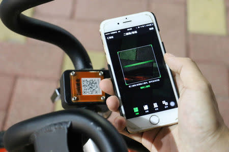 A resident scans a code on a bike of MoBike in Guangzhou, Guangdong Province, China, October 8, 2016. REUTERS/Stringer