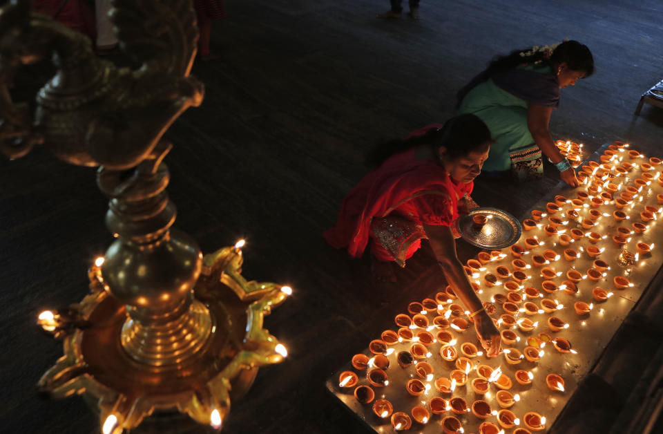 In this Jan. 15, 2020, photo, Sri Lankan ethnic Tamil Hindu devotees light oil lamps during the harvest festival known as 'Thai Pongal' at a Hindu temple in Colombo, Sri Lanka. 'Thai Pongal' which is also known as 'Makar Sankranti' in India, marks the beginning of the sun's northward movement according to the solar calendar and is considered to be auspicious. (AP Photo/Eranga Jayawardena, File)