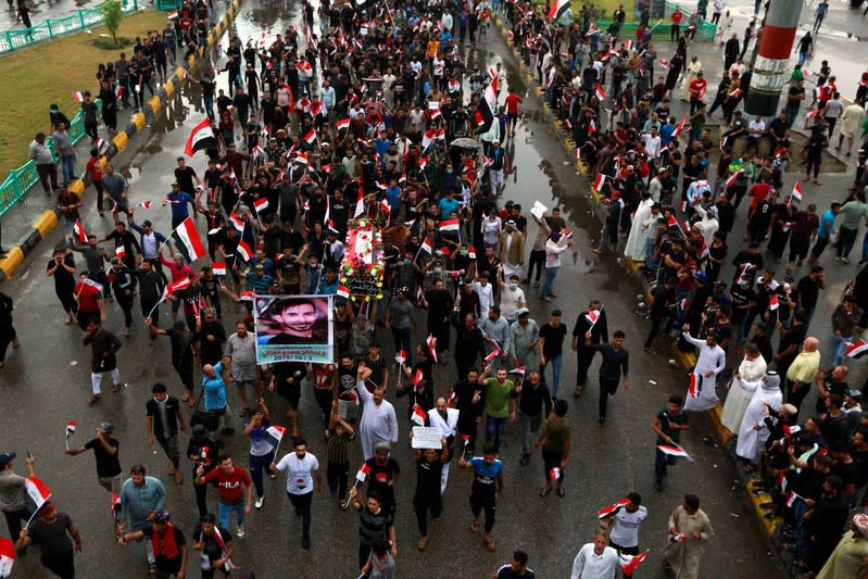 Demonstrators hold the Iraqi flag as they gather during a protest in Najaf