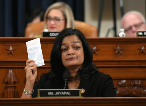 Democratic lawmaker Pramila Jayapal holds up a copy of the Constitution as she votes to impeach President Donald Trump