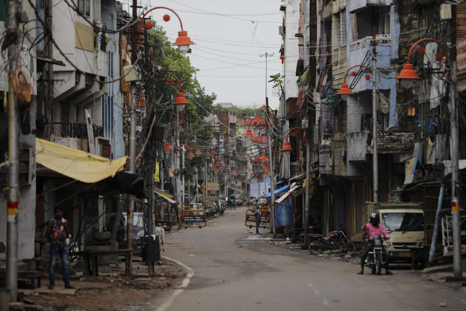 A man rides a bike on a deserted street during fresh lockdown in Prayagraj, India, Saturday, July 11, 2020. In just three weeks, India went from the world’s sixth worst-affected country by the coronavirus to the third, according to a tally by Johns Hopkins University. India's fragile health system was bolstered during a stringent monthslong lockdown but could still be overwhelmed by an exponential rise in infections. (AP Photo/Rajesh Kumar Singh)