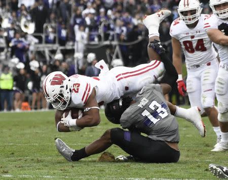 Oct 27, 2018; Evanston, IL, USA; Northwestern Wildcats defensive back JR Pace (13) tackles Wisconsin Badgers running back Jonathan Taylor (23) during the second half at Ryan Field. Mandatory Credit: David Banks-USA TODAY Sports