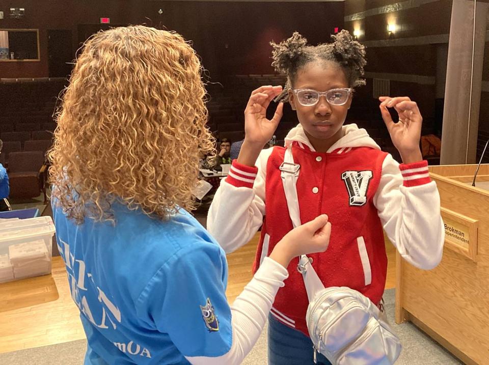 Ashly Espiritusanto, an event coordinator with Optical Academy, helps Ke'Zarria Wayne, 11, try frames for a new pair of glasses. Wayne received a free pair of glasses Feb. 20 during a Glasses2Classes event at East Middle School.