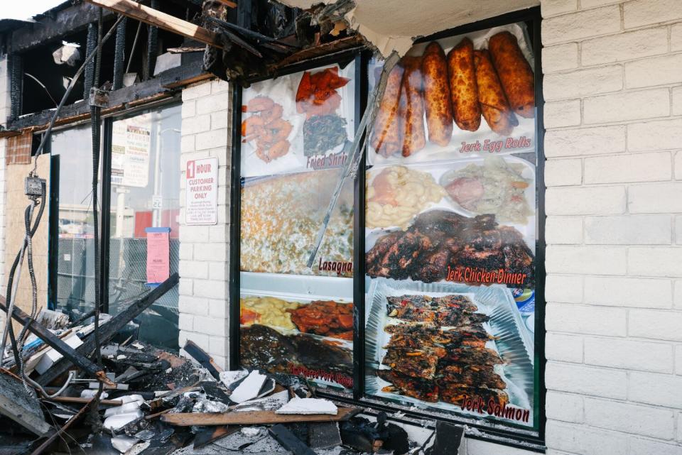 The front of a restaurant with its roof torn open, exposing charred beams.