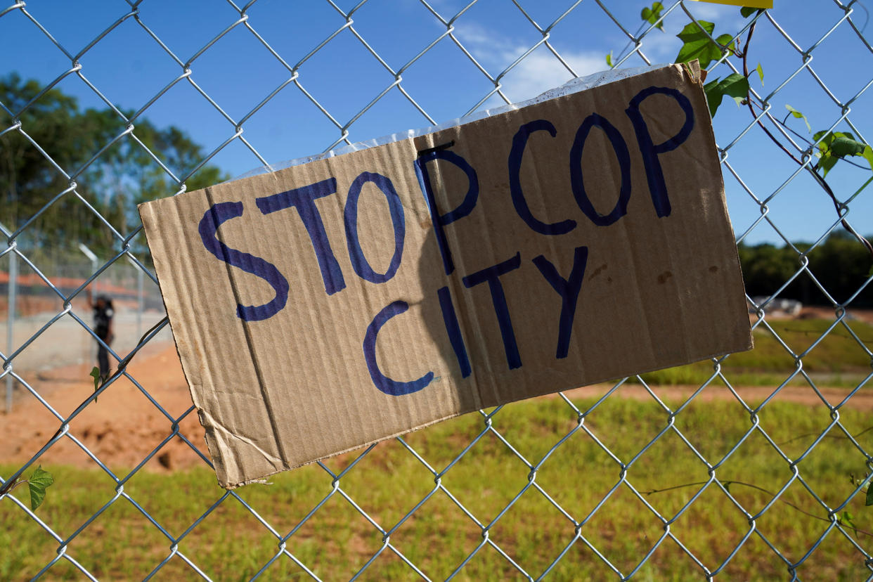 A placard on a fence at the site of a planned Atlanta police training center reads: Stop Cop City.