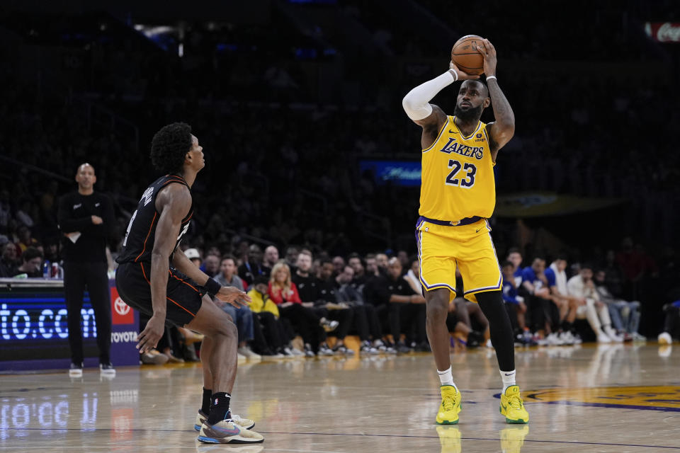 Los Angeles Lakers forward LeBron James, right, shoots as Detroit Pistons forward Ausar Thompson watches during the second half of an NBA basketball game Tuesday, Feb. 13, 2024, in Los Angeles. (AP Photo/Ryan Sun)