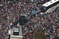 Atlanta Braves players hoist the Commissioner's Trophy from the top of a double decker bus while surrounded by fans as they arrive in the Battery outside Truist Park while the team hosts a World Series championship parade and celebration on Friday, Nov. 5, 2021, in Atlanta. (Curtis Compton/Atlanta Journal-Constitution via AP)