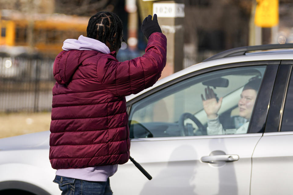 Shamonte Jones, left, talks to a commuter who turned down the offer for him to squeegee clean her vehicle's windshield in exchange for cash, Tuesday, Jan. 10, 2023, in Baltimore. Local officials are rolling out their latest plan to steer squeegee workers away from busy downtown intersections and toward formal employment using law enforcement action and outreach efforts. (AP Photo/Julio Cortez)