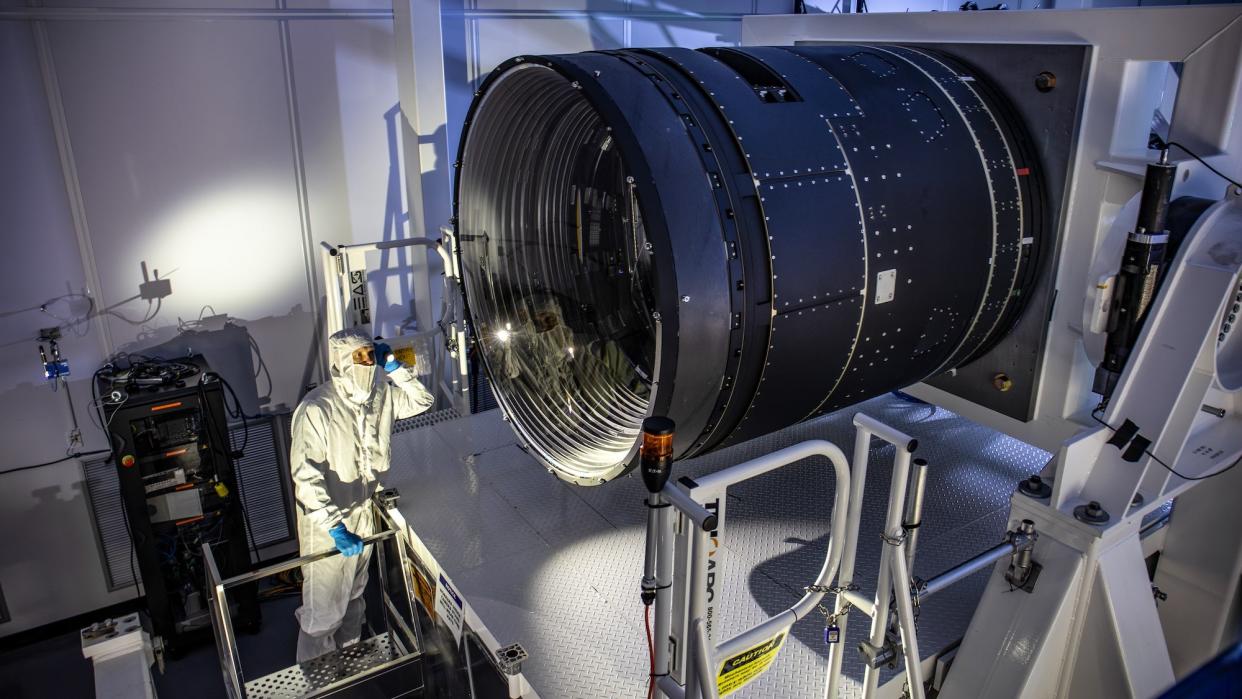 LSST Camera Deputy Project Manager Travis Lange shines a flashlight into the LSST Camera.