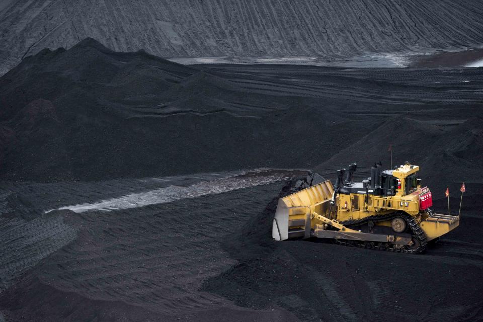 <p>Andrew Harrer / Bloomberg via Getty Images</p> A bulldozer smoothes a coal pile in the storage yard at Consol Energy Inc.