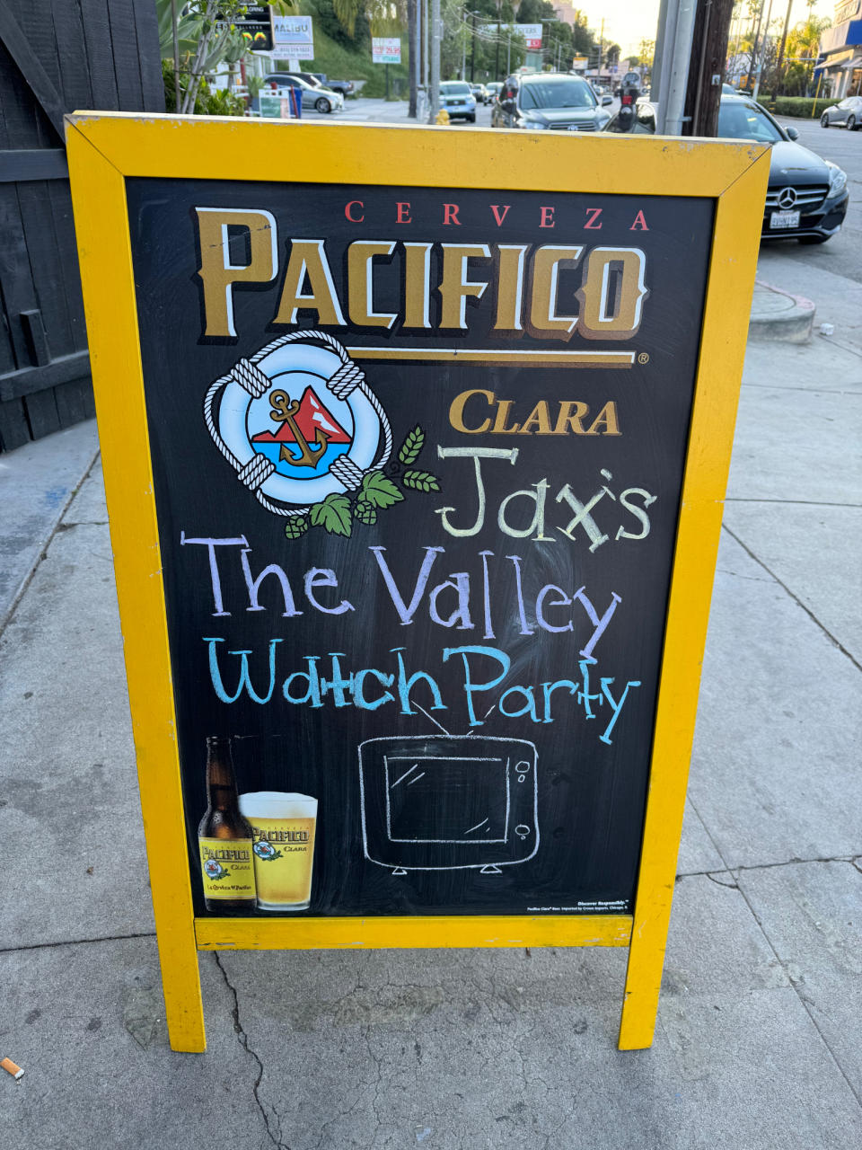 Sidewalk sign advertising Pacifico beer and promoting Jaxi's The Valley Watch Party