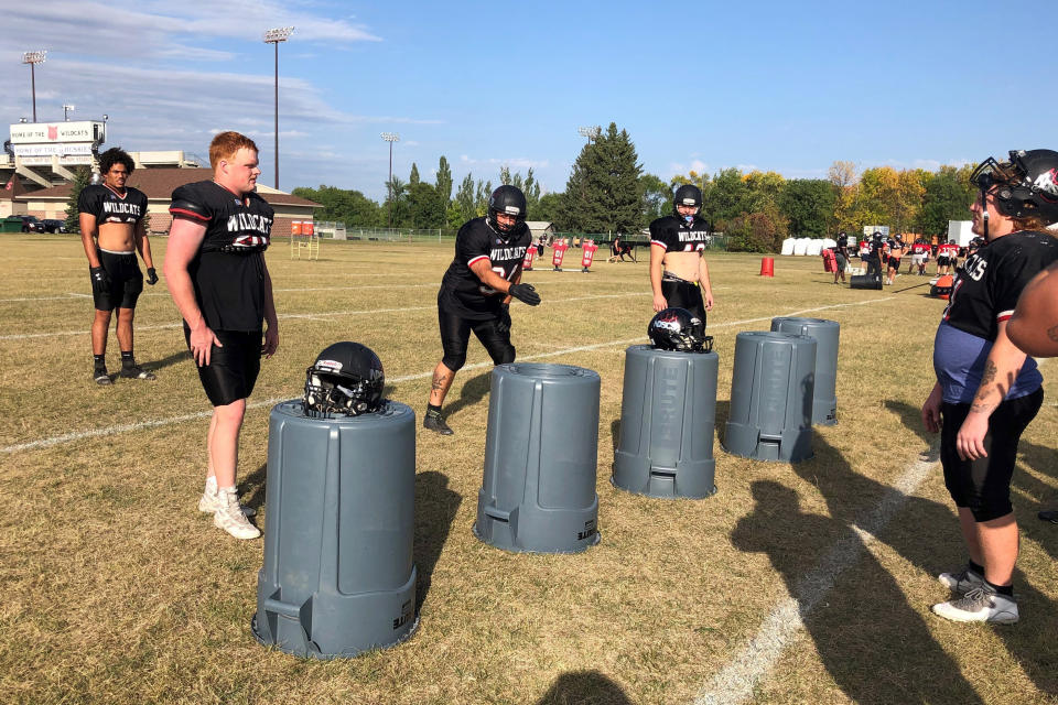 Defensive lineman Ray Ruschel, gesturing at center, a 49-year-old college freshman at North Dakota State College of Science, works on rushing techniques during practice on Tuesday, Sept. 20, 2022, in Wahpeton, N.D. Ruschel who spends his nights working as a mechanic at a local sugar beet factory, is seeking a business management degree at the junior college in hopes of becoming a supervisor at the plant. He plays a dozen snaps or more a game. (AP Photo/Dave Kolpack)