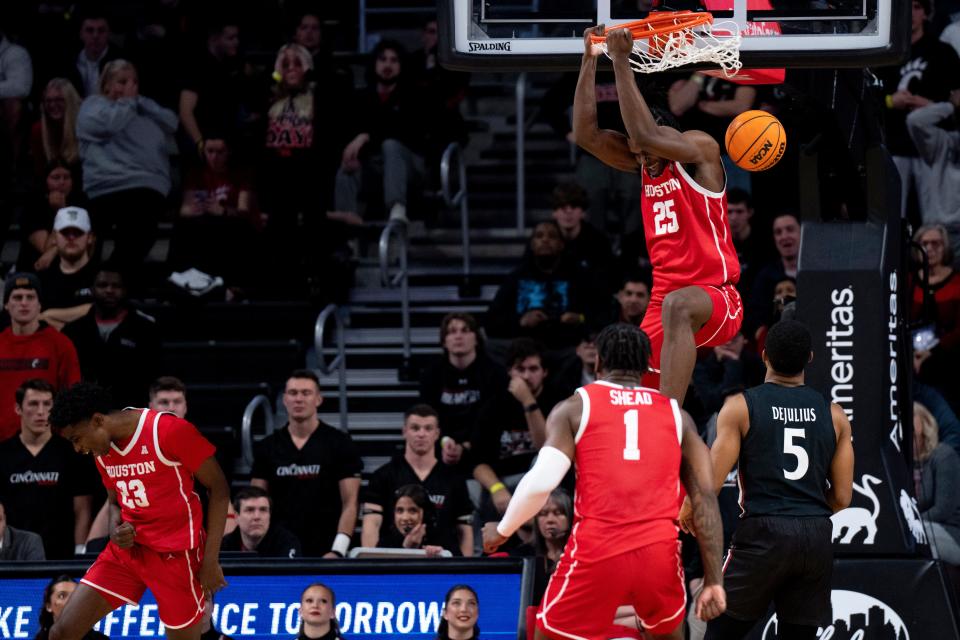 Houston Cougars forward Jarace Walker (25) dunks as Cincinnati Bearcats guard David DeJulius (5) looks on in their men’s basketball game at Fifth Third Arena in Cincinnati on Sunday, Jan. 8. Walker led Houston with 21 points in their 72-59 win.