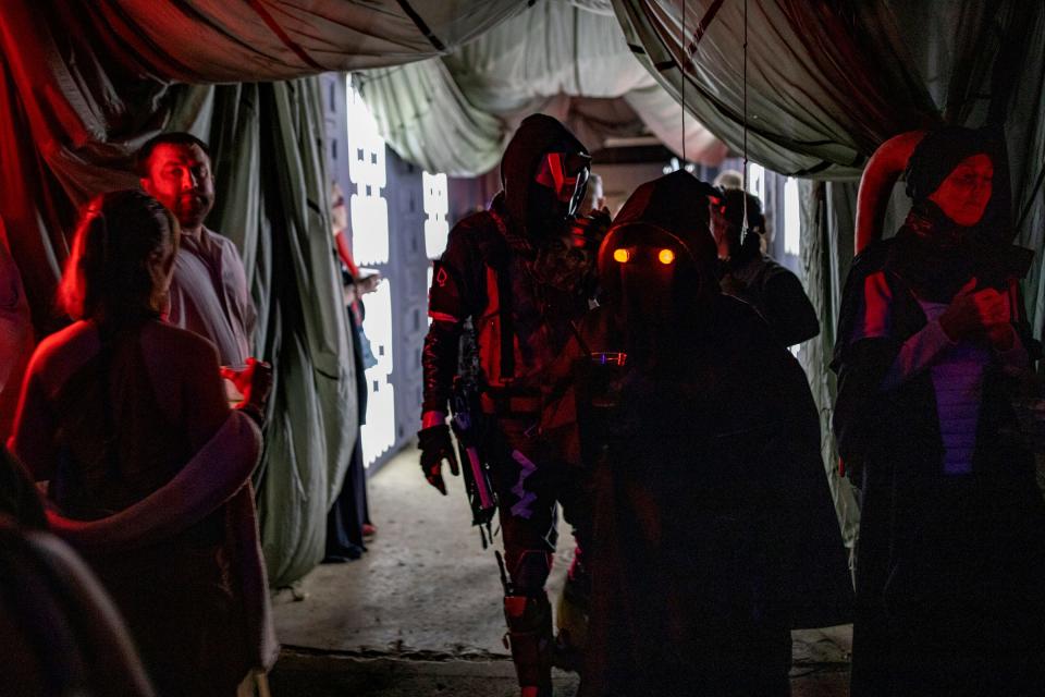 "Star Wars" enthusiasts walk around the Imperial Base that has been taken over by rebels on the planet Tatooine in the "Star Wars" galaxy, six months after the Death Star is destroyed by hometown hero Luke Skywalker, during the Space Dive 313 party at Tangent Gallery in Detroit on Saturday, May 4, 2024.