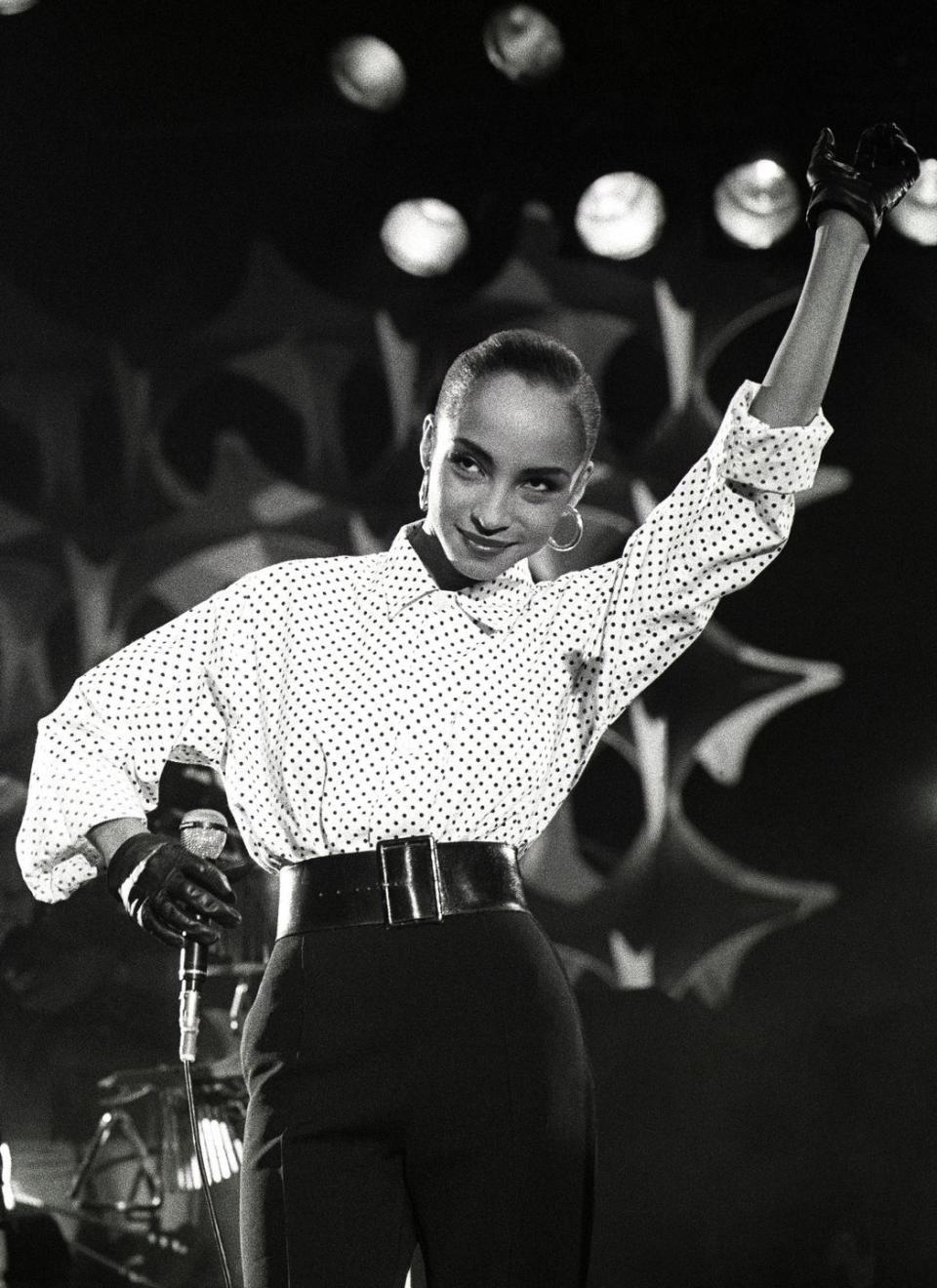 <p>For this performance, the singer Sade styled her oversized polka-dotted shirt with a waist-cinching black belt. </p>