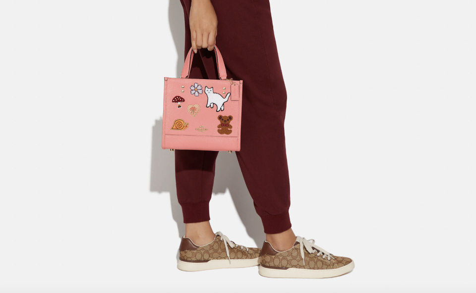 Coach Dempsey Tote 22 With Creature Patches in gold/candy pink (Photo via Coach Outlet)