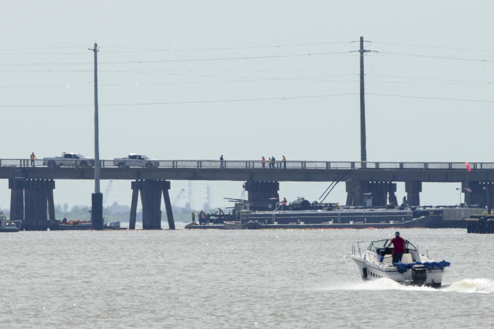 Officials respond after the Pelican Island Bridge was closed when a passing barge struck one of its supports, Wednesday, May 15, 2024, in Galveston, Texas. The accident caused oil to spill into surrounding waters and closing the only road to a smaller and separate island that is home to a university, officials said. (Jon Shapley/Houston Chronicle via AP)