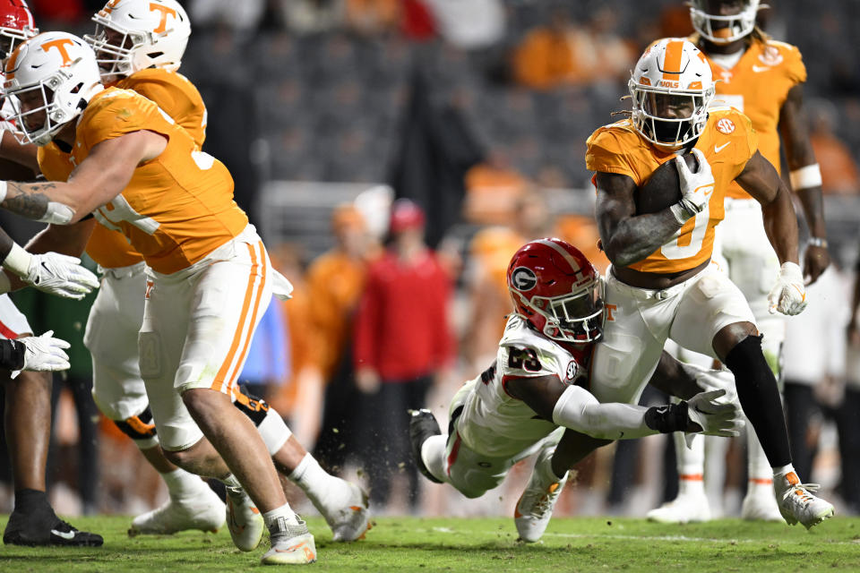 KNOXVILLE, TENNESSEE - NOVEMBER 18: Jaylen Wright #0 of the Tennessee Volunteers gets tackled by Tykee Smith #23 of the Georgia Bulldogs in the fourth quarter at Neyland Stadium on November 18, 2023 in Knoxville, Tennessee. (Photo by Eakin Howard/Getty Images)
