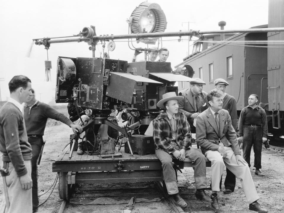 Karl Struss (right) sits next to Bing Crosby on the set of Rhythm Range.