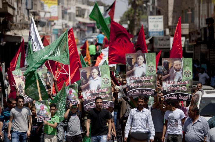 CLICK IMAGE for slideshow: Supporters of Hamas hold posters of three senior commanders of the Hamas military wing, Mohammed Abu Shamaleh, Raed Attar and Mohammed Barhoum, who were killed in Thursday's Israeli strikes, during a demonstration to protest against Israel and to support people in Gaza, in the West Bank city of Ramallah on Friday, Aug. 22, 2014. (AP Photo/Majdi Mohammed)