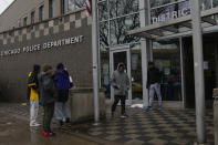 Migrants stand outside of the Chicago Police Department 1st district station Friday, Dec. 1, 2023, in Chicago. Officers at the station said they were unaware of when the remaining migrants might be moved from the station, as many remained on the floors inside the station. (AP Photo/Erin Hooley)