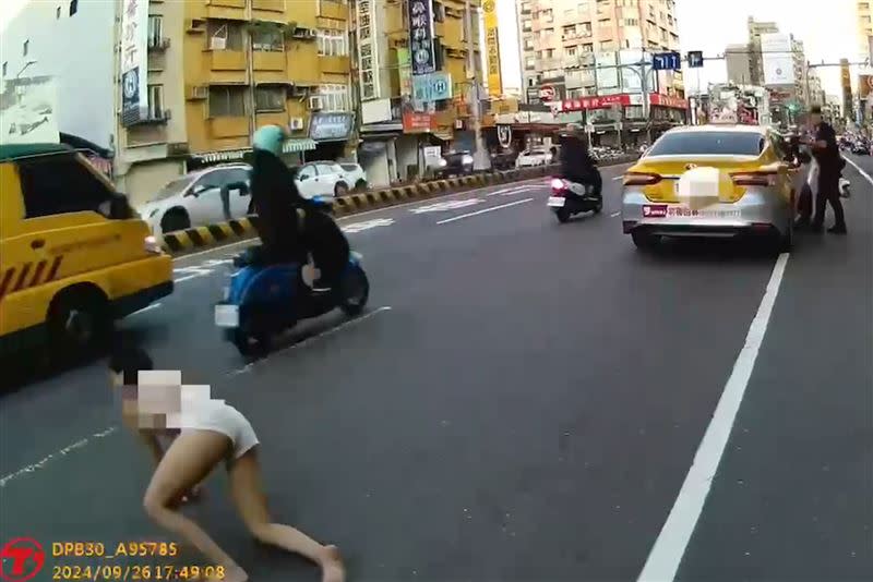 侯女在車道上爬行，警方也立即勸阻。（圖／翻攝畫面）