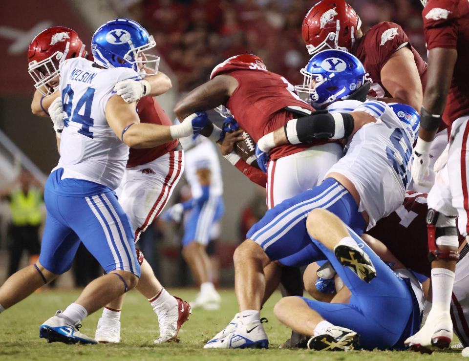 The Brigham Young Cougars defense sacks Arkansas Razorbacks quarterback KJ Jefferson (1) at Razorback Stadium in Fayetteville on Saturday, Sept. 16, 2023. BYU won 38-31. | Jeffrey D. Allred, Deseret News