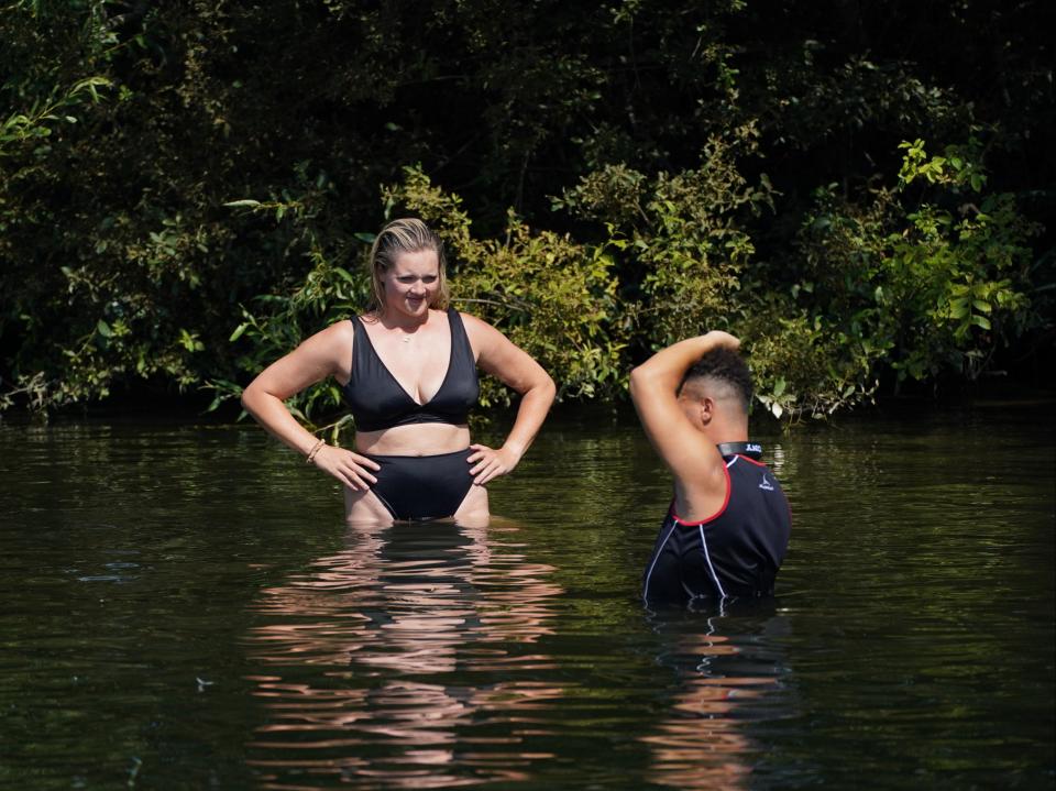 A couple keep cool in the River Thames near Chertsey in Surrey (Steve Parsons/PA)